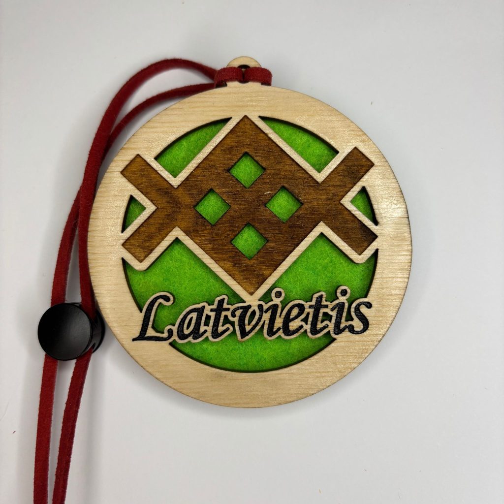 Tumša koka auto gaisa atsvaidzinātājs ar Akas zīmes gravējumu un koši zaļu filca pamatni.